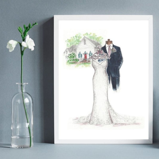 A framed sketch of a bride and groom in a house setting, displayed on a grey background with a vase of white flowers to the side.